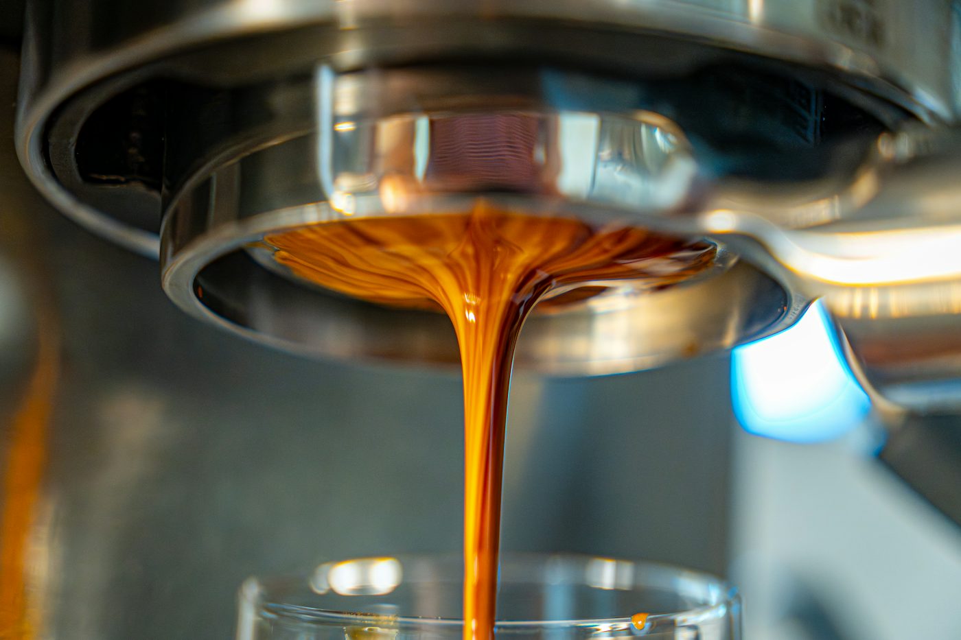 Espresso pouring from the machine into a small glass