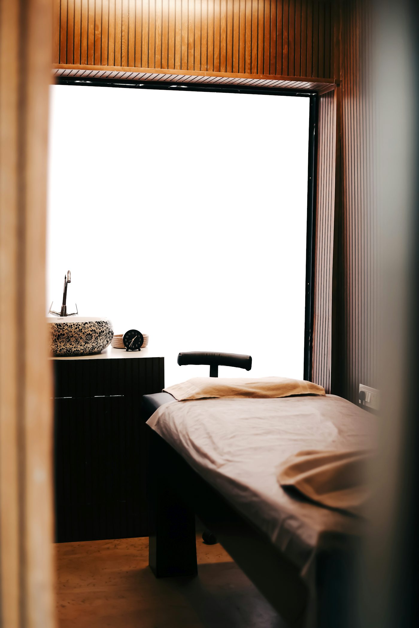 A quiet treatment room with a couch and a small basin